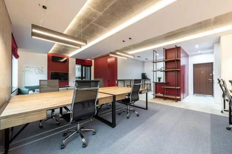Spacious contemporary office space with wooden desks and modern decor.