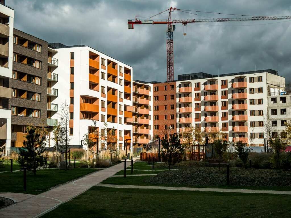 pexels-photo-34360419-34360419 Newly built residential buildings under cloudy skies with a construction crane.